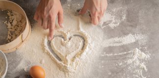 serduszko narysowane na rozsypanej na blacie mące
